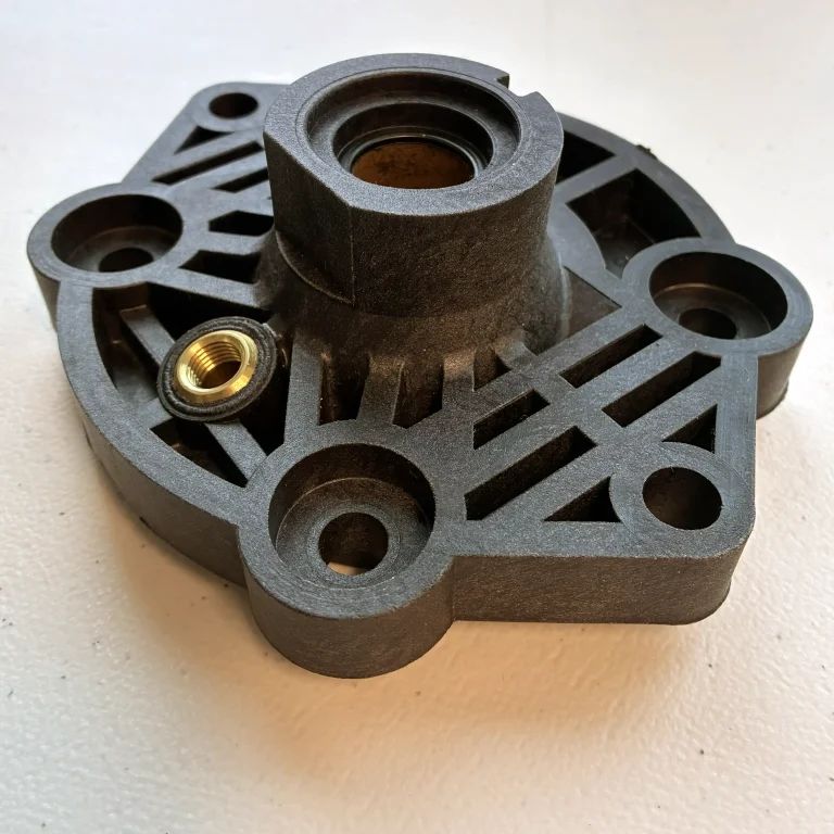 Engine part overmolded with brass inserts.