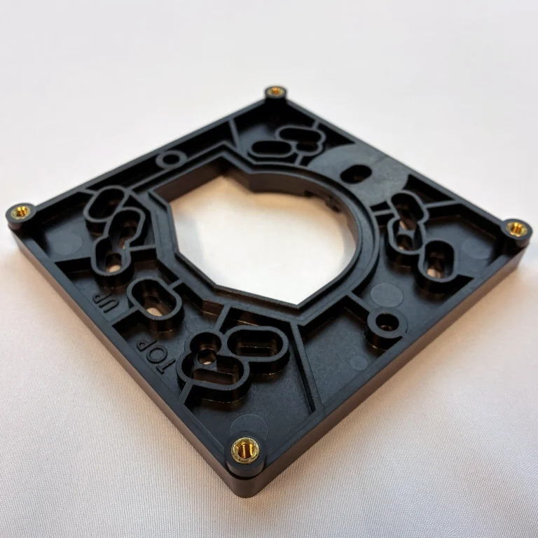 Plastic interface with brass overmolded inserts.
